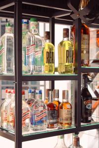 a shelf filled with lots of bottles of alcohol at Hotel Curazao Natural Living cerca a charcos naturales y tobogán extremo in Cocorná