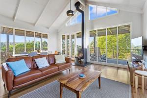 een woonkamer met een bank en een tafel bij Cape Cottages - Ollies View in Tanybryn