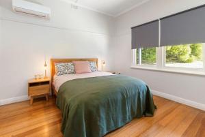 een witte slaapkamer met een bed en een raam bij Cape Cottages - Ollies View in Tanybryn