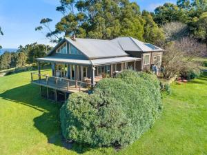 een groot huis met een dak op een groen veld bij Cape Cottages - Ollies View in Tanybryn