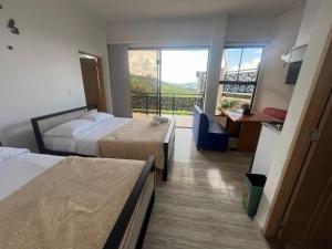 a hotel room with two beds and a balcony at Hotel Curazao Natural Living cerca a charcos naturales y tobogán extremo in Cocorná +27 photos