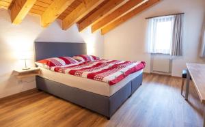 a bedroom with a bed in a room with wooden floors at Edelweiss Pany in Pany