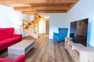 a living room with a red couch and blue chairs at Edelweiss Pany in Pany