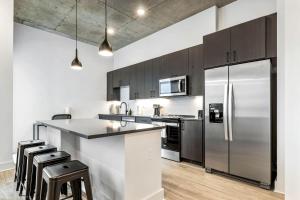 a kitchen with a stainless steel refrigerator and cabinets at Modern Channelside 1BD Apartment | Close to DT! in Tampa