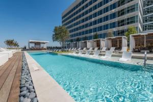 a swimming pool with chairs and a building at Modern Channelside 1BD Apartment | Close to DT! in Tampa