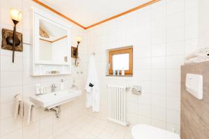 bagno bianco con lavandino e servizi igienici di "Ferienwohnung Ess" - Annehmlichkeiten von 4-Sterne Familien-und Wellnesshotel Viktoria können mitbenutzt werden a Oberstdorf