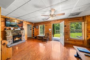 a living room with a fireplace and a ceiling fan at Heaven Sent by American Patriot Getaways in Henderson Springs