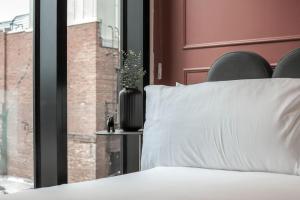 a bed with a white pillow next to a window at Cozy Downtown Studio Free Pool Close to DT in Tampa