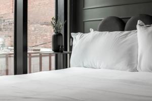 a bed with white pillows in a room with a window at Ybor Studio Delight Free Parking Close to DT in Tampa