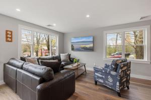a living room with a leather couch and chairs at Central Location 4BR w Boat Slip Option in Gilford