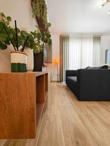 Una sala de estar con un sofá y algunas plantas. en The Urban Nest, en Tal-Pietà