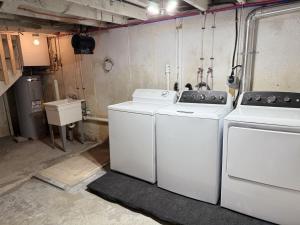 a laundry room with two washing machines and a sink at Central Location 4BR w Boat Slip Option in Gilford +48 photos
