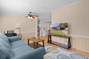 a living room with a blue couch and a table at Sunlit 2BR with Lanai on Golf Cart Path in Lady Lake