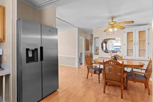 a kitchen and dining room with a stainless steel refrigerator at Sunlit 2BR with Lanai on Golf Cart Path in Lady Lake