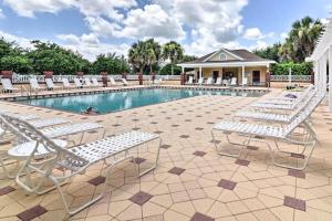 a pool with chaise lounge chairs and a group at Sunlit 2BR with Lanai on Golf Cart Path in Lady Lake