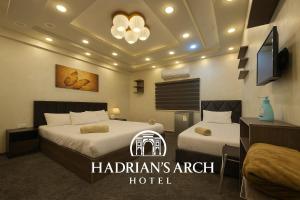 杰拉什Hadrian's Arch的一间有两张床和一台电视的酒店房间