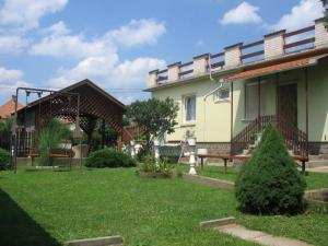 a yard with a house and a picnic table in front of it at Kovács Vendégház in Mátraderecske