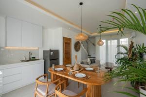 a kitchen and dining room with a wooden table and chairs at Sunrise Bliss 13 Ricefield View Private Pool Villa By Bali Bliss Properties in Dalung