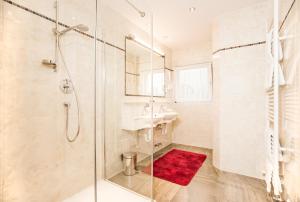 y baño con ducha y alfombra roja. en Hotel Alpenhof Kristall en Mayrhofen