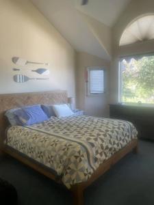 a bedroom with a bed in a room with a window at 3BR Lake Winnipesaukee Condo with Sandy Beach in Laconia
