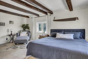 a bedroom with a blue bed and a chair at Spacious Luxe Condo in Historic Downtown Wolfeboro in Wolfeboro
