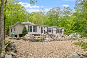 a house in the woods with a gravel yard at Cozy 3BR with Firepit and Boat Slip Option in Moultonborough