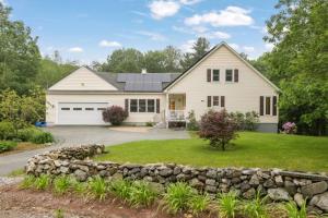 a white house with a stone wall at 3BR with Hot Tub Arcade Games Near Lake and Slopes in Gilford