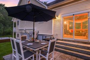 a table with an umbrella on a patio at 3BR with Hot Tub Arcade Games Near Lake and Slopes in Gilford