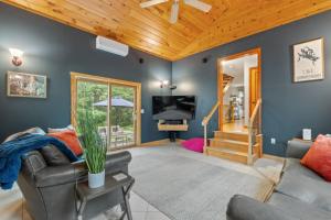 a living room with blue walls and a wooden ceiling at 3BR with Hot Tub Arcade Games Near Lake and Slopes in Gilford