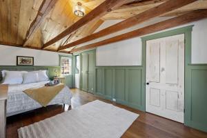 a bedroom with a bed and a wooden ceiling at Rustic Beauty, Fireplace, Cows & Mountain Views in Gilmanton