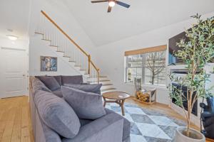 a living room with a blue couch and stairs at 3BR plus Loft with Pool, Firepit, Walk to Boardwalk in Laconia