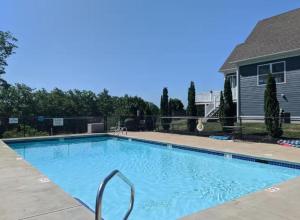 a swimming pool in front of a house at 3BR plus Loft with Pool, Firepit, Walk to Boardwalk in Laconia