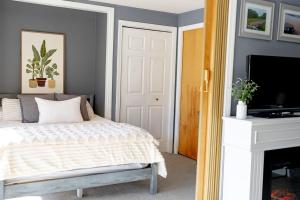 a bedroom with a bed and a flat screen tv at Walk to Concerts Beach with Pool View in Gilford