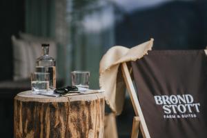 a bottle of alcohol sitting on a table with a chair at Brondstott Farm & Suites Kronplatz in Riscone