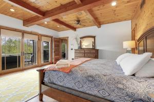 a bedroom with a large bed and a wooden ceiling at Peekaboo Lake View Luxury 5BR with Game Room in Gilford