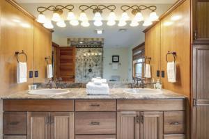 a bathroom with two sinks and a large mirror at Peekaboo Lake View Luxury 5BR with Game Room in Gilford +87 photos