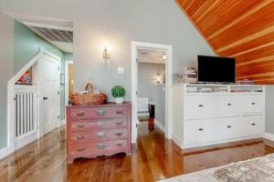 ein Schlafzimmer mit einer Kommode und einem TV darüber in der Unterkunft Bright and Cozy Studio w Hot Tub Walk to Lake in Wolfeboro