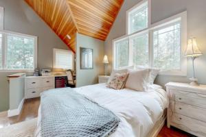 ein Schlafzimmer mit einem großen weißen Bett und Fenstern in der Unterkunft Bright and Cozy Studio w Hot Tub Walk to Lake in Wolfeboro