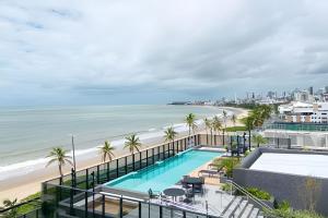 a view of the beach from a building with a swimming pool at Flat à beira-mar Beach Haus - MyFlats Hospedagens in Tambaú