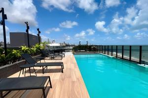 a swimming pool with a view of the ocean at Flat à beira-mar Beach Haus - MyFlats Hospedagens in Tambaú