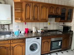 a kitchen with wooden cabinets and a washing machine at El COTO - VUT 6639 AS in Gijón
