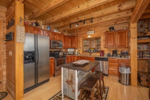 eine Küche mit Holzschränken und einem Edelstahlkühlschrank in der Unterkunft Heavenly Homestead by American Patriot Getaways in Park Settlement