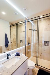a bathroom with a shower and a sink and a toilet at Distrito Puerto, Ocean & Mangrove Views in Puerto Morelos