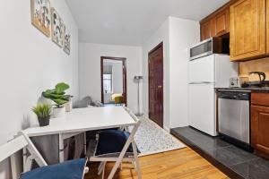 a kitchen with white appliances and a white table and chairs at Prime Manhattan Location Family Friendly 2BR in New York