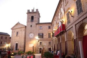 un bâtiment avec une tour d'horloge et une église dans l'établissement Marche Hills, à Morrovalle