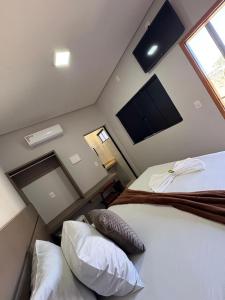 Un dormitorio con dos camas y un televisor en la pared. en Belke Hotel, en Mineiros