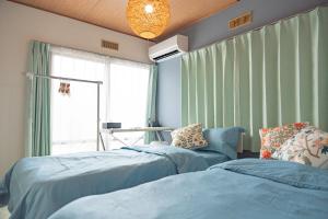 two blue beds in a room with a window at Kyoto Fushimi Yado - Vacation STAY 19114 in Kyoto
