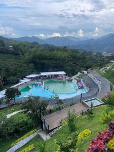 a large swimming pool in the middle of a park at Hotel Curazao Natural Living cerca a charcos naturales y tobogán extremo in Cocorná