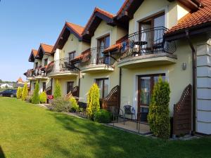 a row of houses with balconies and tables and chairs at VILLA KORA in Rowy
