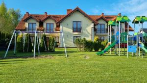 a playground in a yard in front of a house at VILLA KORA in Rowy